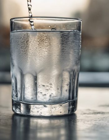 A hyper realistic photo of a glass of water with condensation, making it look refreshingly real.